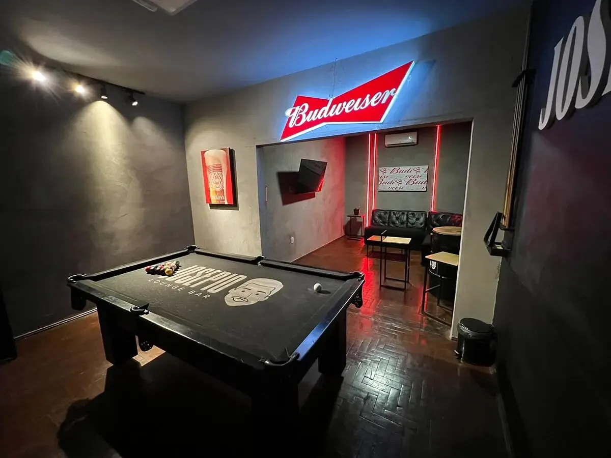 Sala VIP do Josepio com mesa de sinuca profissional, parede com o nome Josepio e neon da Budweiser
